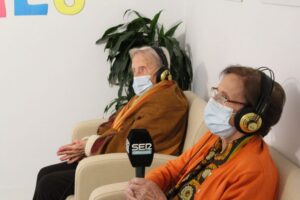 mujer mayor con mascarilla sostiene el microfono de la cadena ser