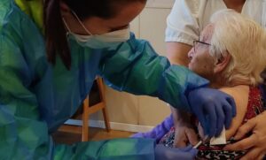 mujer recibiendo la primera dosis de la vacuna
