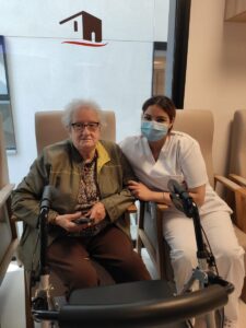 Mujer mayor junto a su cuidadora