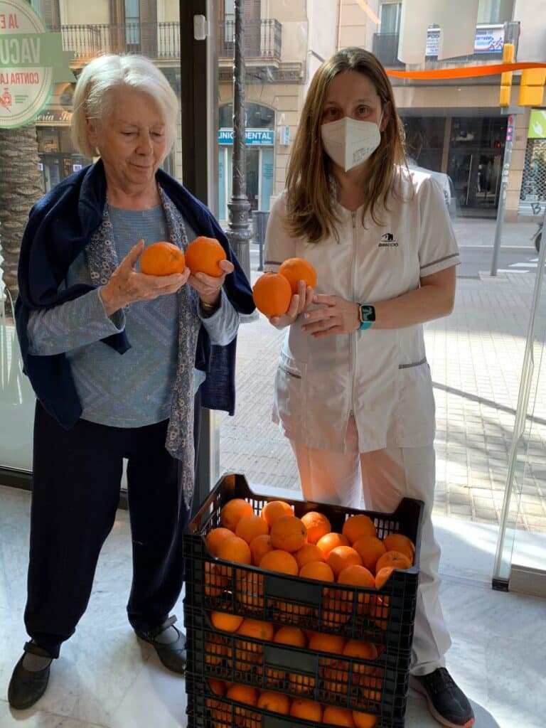 dos mujeres sujetando dos naranjas